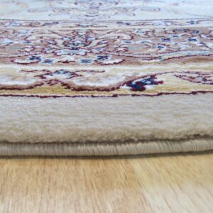Ornate cream rug with red and blue accents, showing the pile edge resting on light wood flooring.
