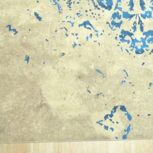 Abstract blue shapes accent a textured beige rug lying on light wood flooring.