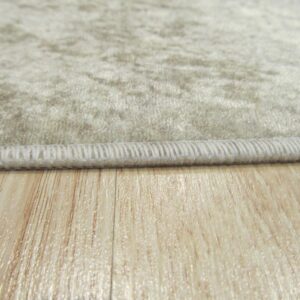 Textured beige rug edge with binding rests on a glossy light wood floor.