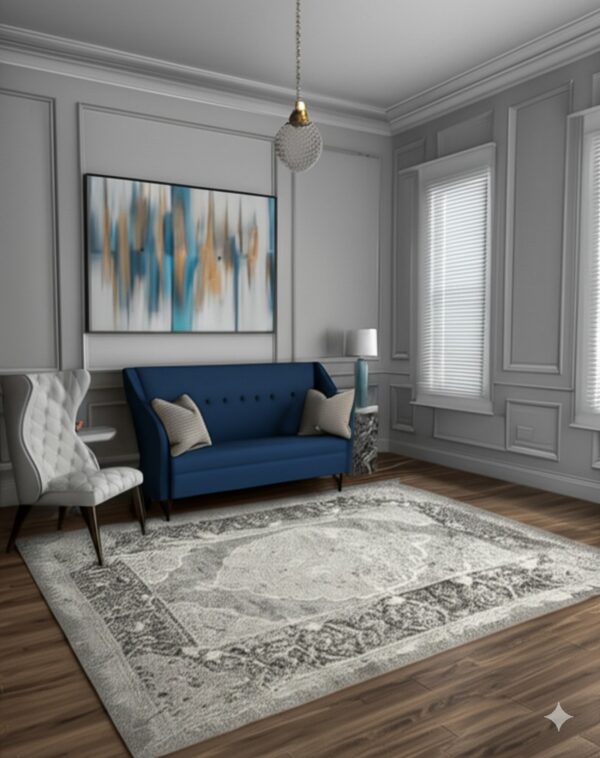 A gray distressed traditional rug covers wood floors beneath a blue sofa and white chair.
