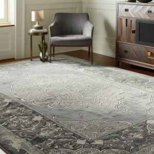 Gray and light-toned rug with a carved traditional pattern anchors a seating area with wood floors.