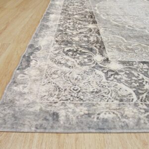 Close-up of a low-pile gray and white distressed traditional rug on light wood plank flooring.