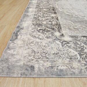 Close-up of a low-pile gray and off-white rug featuring a distressed traditional pattern on light wood flooring.