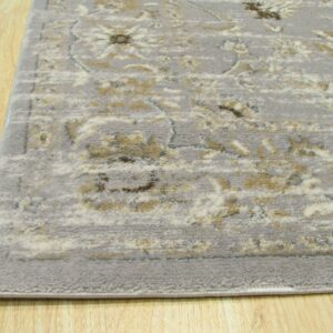 Low-pile gray rug featuring distressed cream and tan classical patterns on light wooden flooring.