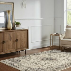 Cream and grey patterned rug on dark wood floor, next to a wood console and beige chair.