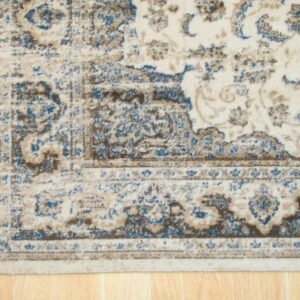 Distressed cream rug with blue and brown traditional patterns seen on light hardwood flooring.