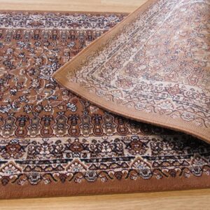 Close-up of a brown floral patterned rug curled back, revealing the light woven backing on a wood floor.