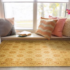 Yellow traditional rug in a sunlit reading nook next to sheer curtains and colorful pillows.