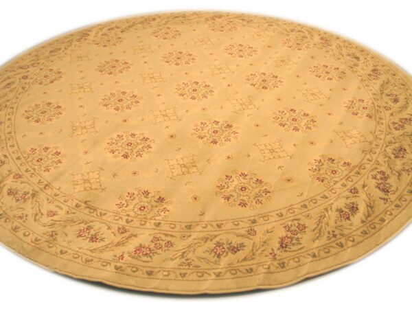 A round tan rug displays a repeating red and brown traditional floral pattern and a wide decorative border.