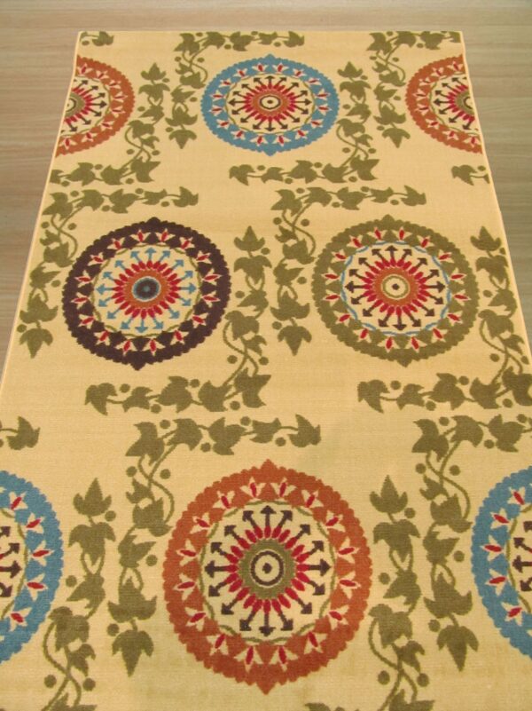 Yellow runner rug featuring alternating colorful medallions and connecting olive green leafy vines on wood flooring.