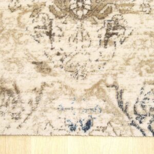 Distressed beige rug featuring faded brown and blue patterns rests on light blonde hardwood floor.