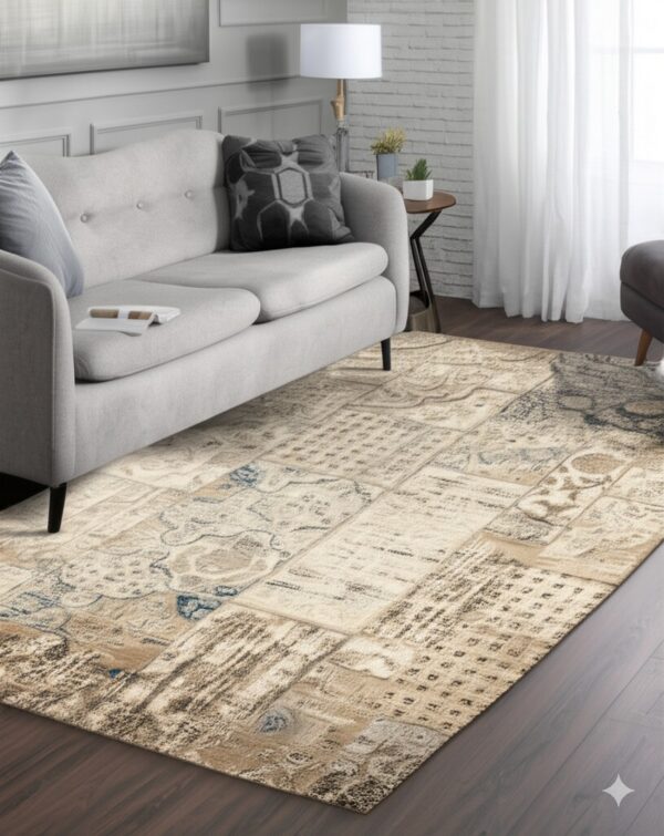 Light beige and brown patchwork rug with distressed blue details under a gray sofa on wood floor.