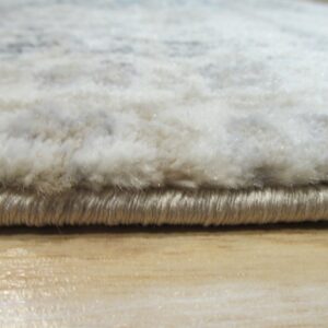 Close-up of the shaggy white pile rug edge with tan binding resting on a light wood floor.
