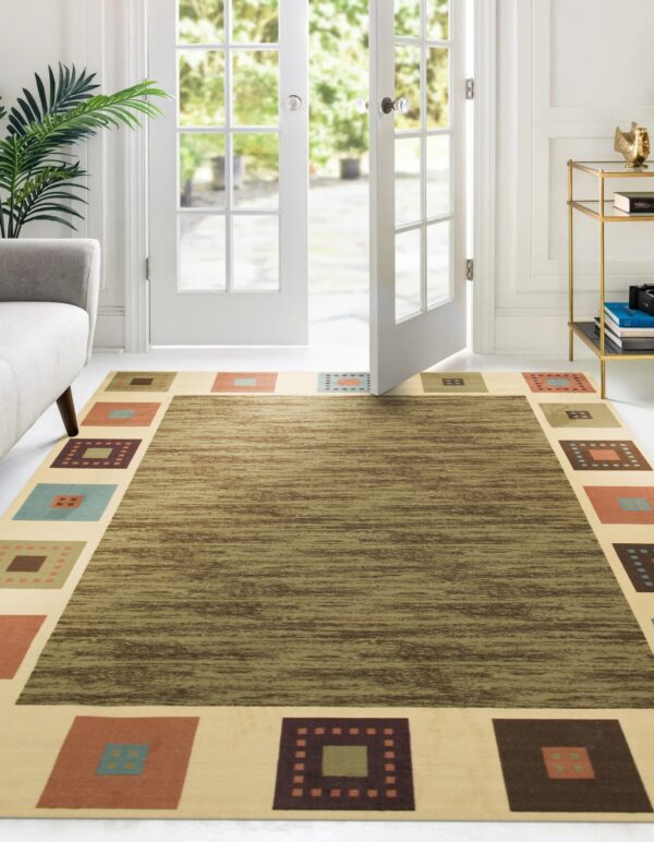 Olive green striated rug with a cream border featuring multi-colored geometric squares in a bright room.