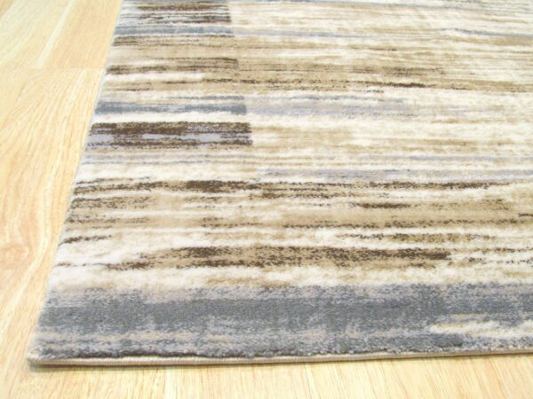 Low-pile rug featuring abstract horizontal stripes in cream, brown, and slate gray on light wood floor.