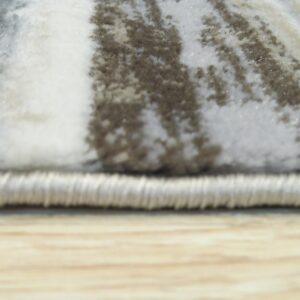 The rug's edge and high pile feature streaked gray, white, and taupe abstract patterns resting on wood flooring.