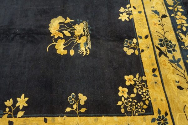 Navy and gold rug showing elaborate floral patterns and a detailed mythical figure on a soft pile.