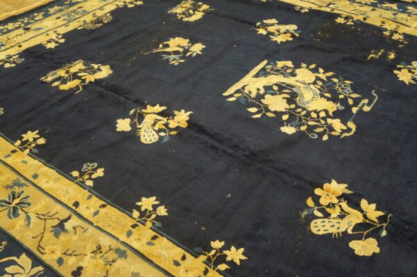 High-pile navy rug detailed with golden flowers and stylized peacocks, framed by a broad yellow border.