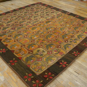 Textured rug with yellow, red, and green hexagonal floral motifs on a distressed plank wood floor.
