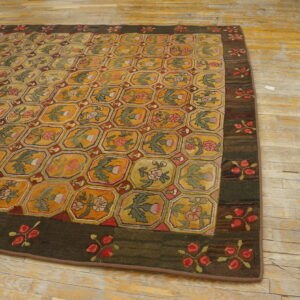 Mustard and green rug featuring an octagonal floral lattice pattern and a wide dark brown border on distressed wood floors.