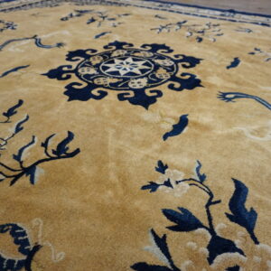 Plush tan rug with intricate indigo floral patterns and a detailed center medallion.