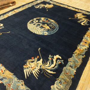 Navy blue rug with a cream dragon medallion and bird figures lies on glossy yellow wood floors.