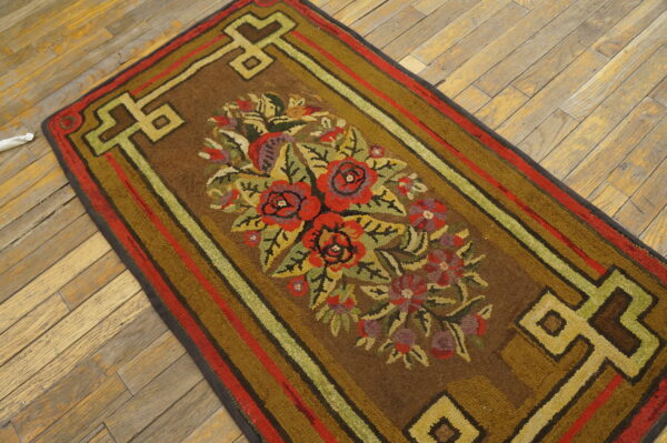 Textured brown runner featuring red and green floral designs and geometric borders on distressed wood planks.