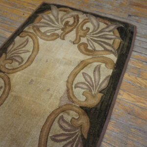 Beige loop pile rug with scrolling brown, purple, and dark green borders on distressed wood planks.