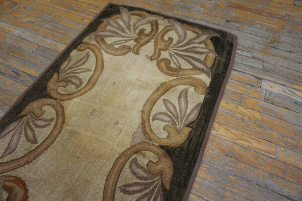 Beige loop pile rug with scrolling brown, purple, and dark green borders on distressed wood planks.
