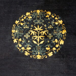Dark blue rug with a central medallion pattern featuring bright gold and deep teal botanical motifs.