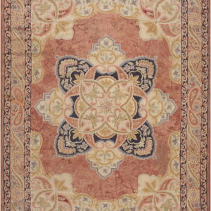 Terracotta and cream traditional medallion rug featuring navy blue and pastel floral carvings.