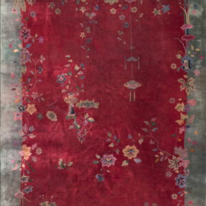 Red low-pile rug with a wide dusty teal border patterned with multicolored antique floral vines.
