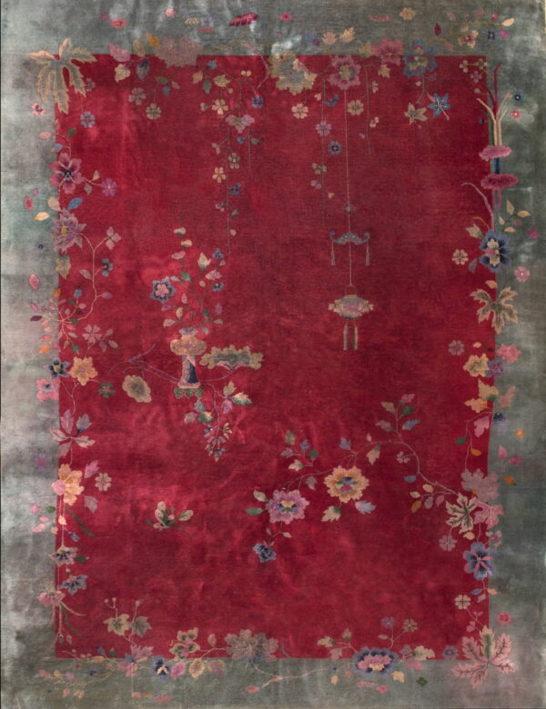 Red low-pile rug with a wide dusty teal border patterned with multicolored antique floral vines.