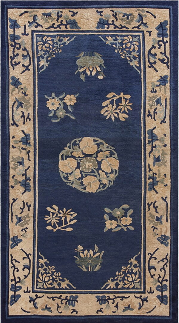 Navy blue rug with a wide tan border and stylized gold and sage floral patterns throughout the field.