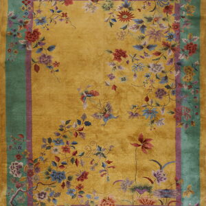 Golden yellow high-pile rug featuring a vibrant, multi-colored floral pattern and a broad teal outer border.