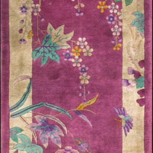 Long fuchsia rug with tan borders decorated with cascading vines and purple, green, and yellow flowers.