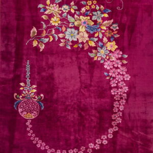 Deep magenta rug with high pile features an asymmetrical floral garland and medallion in multicolor tones.