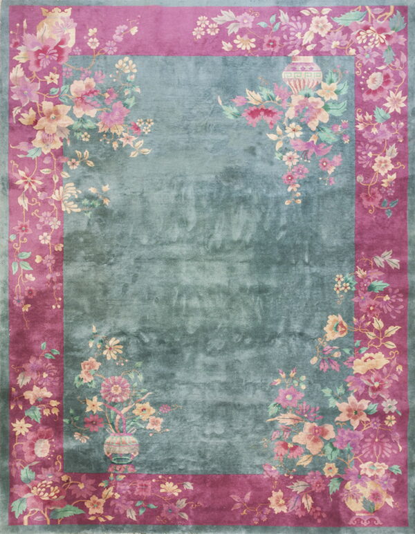 Low-pile rug with a mottled teal center and wide magenta border adorned with detailed pink flowers.