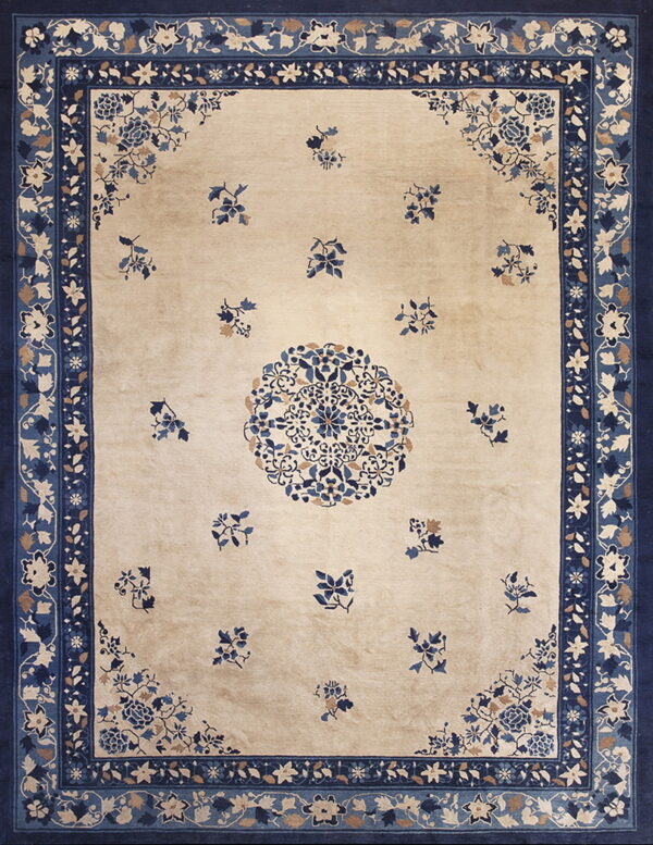 Beige rug with navy borders and detailed blue and tan floral patterns across the field.
