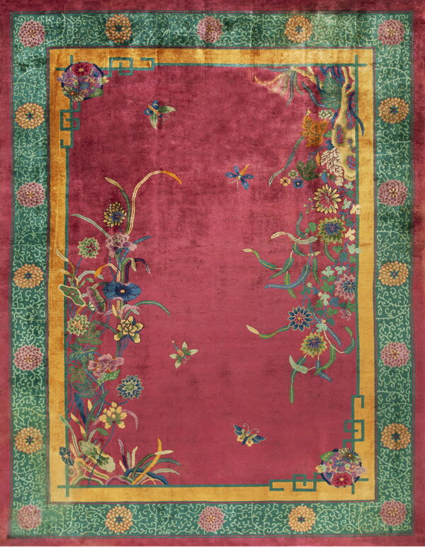 Fuchsia rug field with intricate multicolored floral sprays, framed by gold and teal green patterned borders.