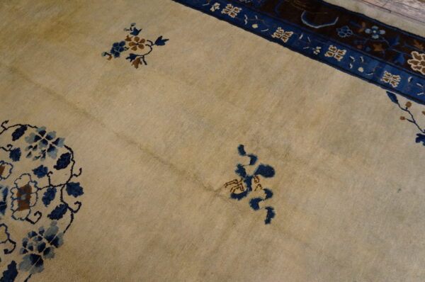 Beige rug field featuring navy and brown scattered floral designs and a vibrant blue patterned major border.