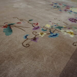 Medium-pile taupe rug featuring colorful, flowing floral and vine motifs in red, blue, and yellow.