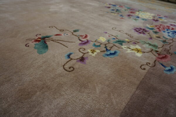Medium-pile taupe rug featuring colorful, flowing floral and vine motifs in red, blue, and yellow.