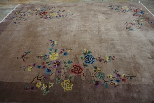 High pile brown rug featuring an asymmetrical design of multicolored flowers and butterflies on a neutral field.