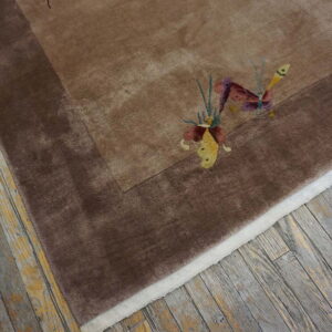 Plush brown rug with a darker border and colorful butterfly accents rests on distressed hardwood floors.