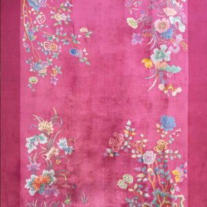 Deep pink rug with a plush texture and pastel floral branches decorating the sides and corners.