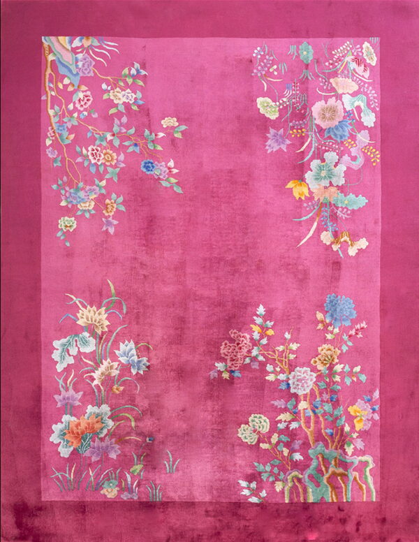 Deep pink rug with a plush texture and pastel floral branches decorating the sides and corners.