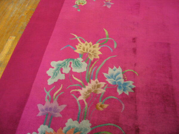 Magenta rug with yellow, blue, and green floral motifs borders a light plank wood floor.