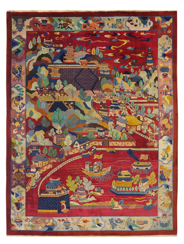 Multi-colored scenic rug on a red field depicting detailed asian architecture, hilly landscape, and boats on water.
