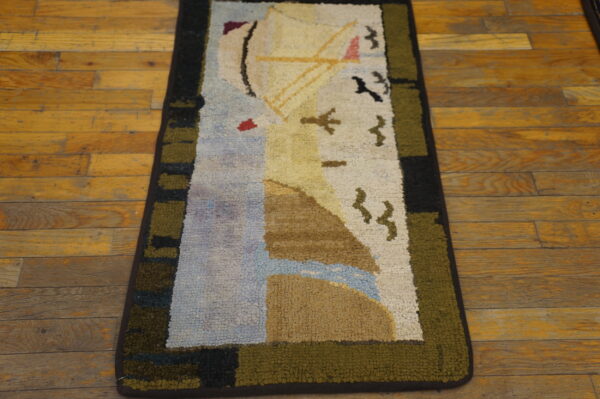 A colorful loop pile area rug with an abstract sailboat design rests on distressed hardwood flooring.